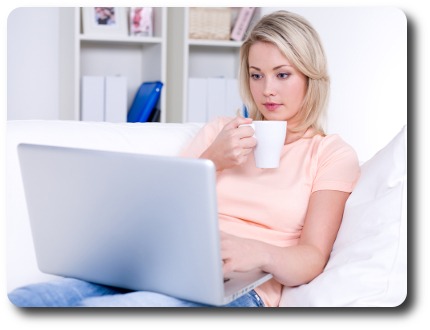 Woman looking at laptop with coffee